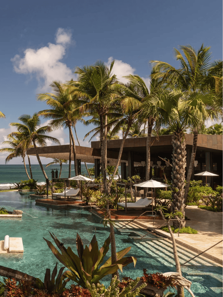 Luxurious tropical resort with pool, palm trees, and ocean view for relaxing vacations in paradise.