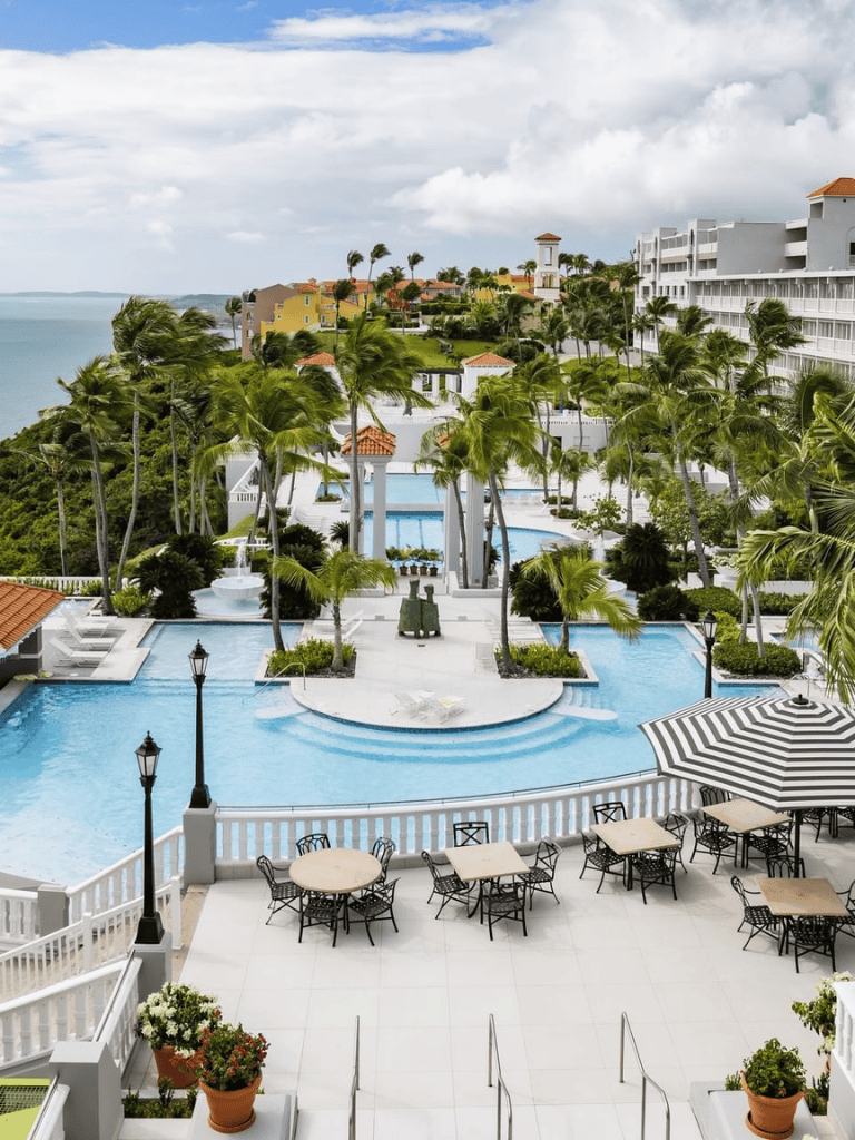 Luxurious ocean-view resort pool surrounded by palm trees and outdoor seating at QuestForDirections.