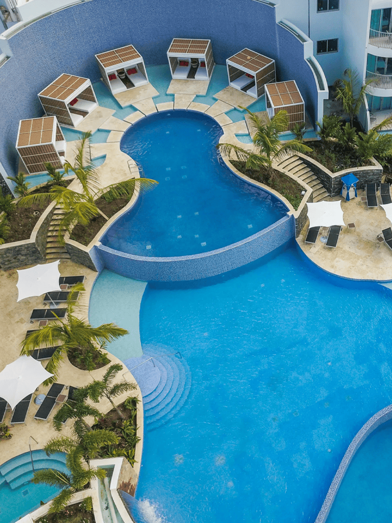 Vibrant hotel pool area with cabanas, loungers, and lush landscaping at QuestForDirections.