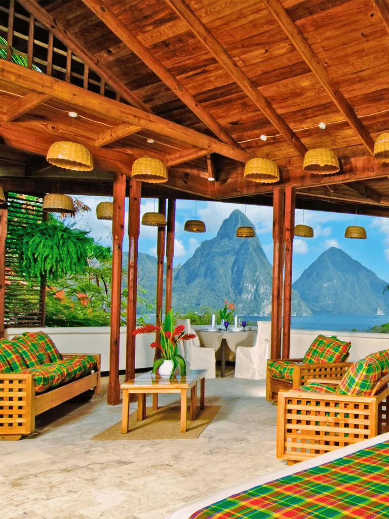 Vibrant outdoor lounge with beautiful mountain views and wooden roof structure, tropical decor, and colorful cushions.