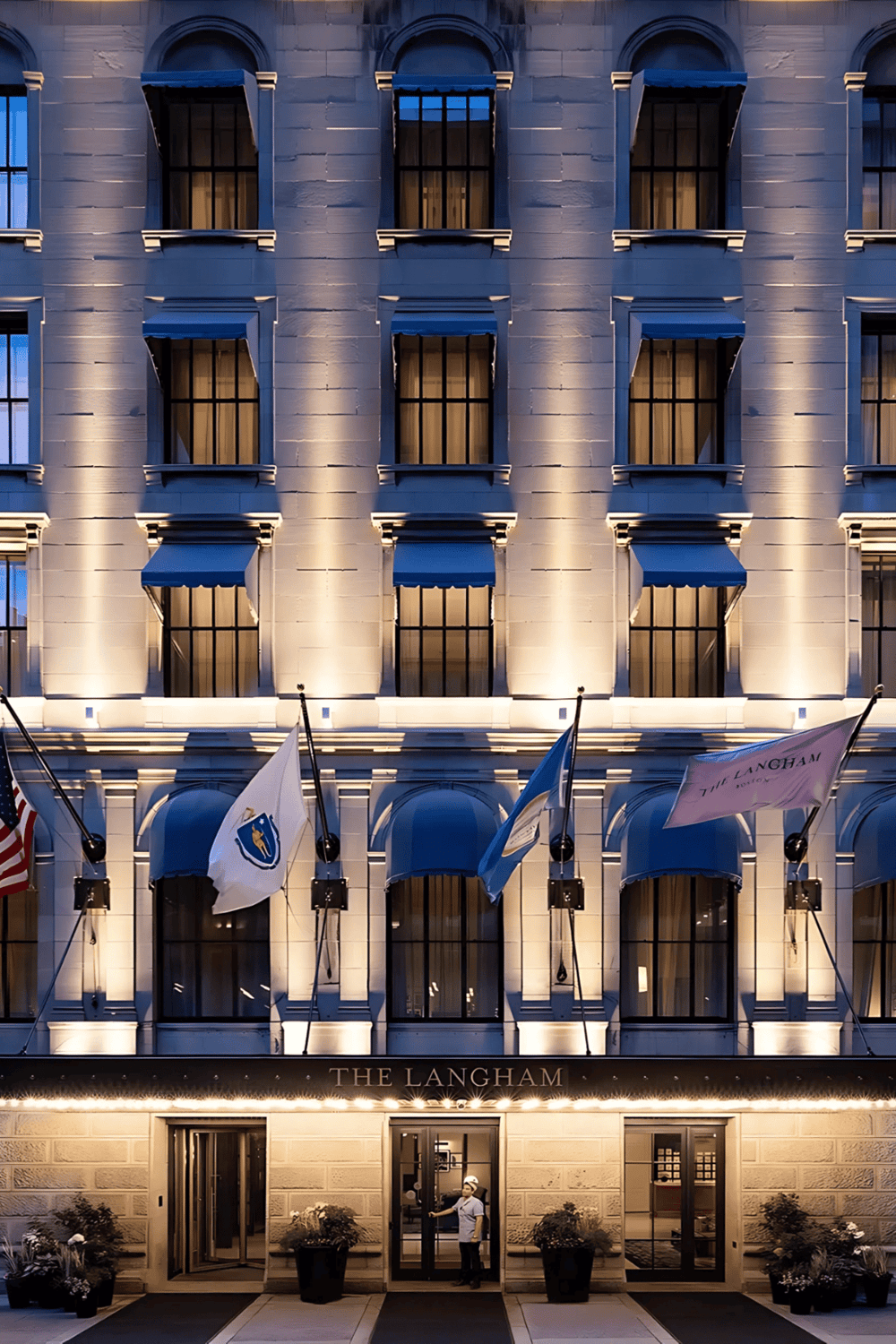 灯光点亮的豪华酒店外观 nighttime cityscape with elegant architecture and flags, showcasing luxury hospitality.