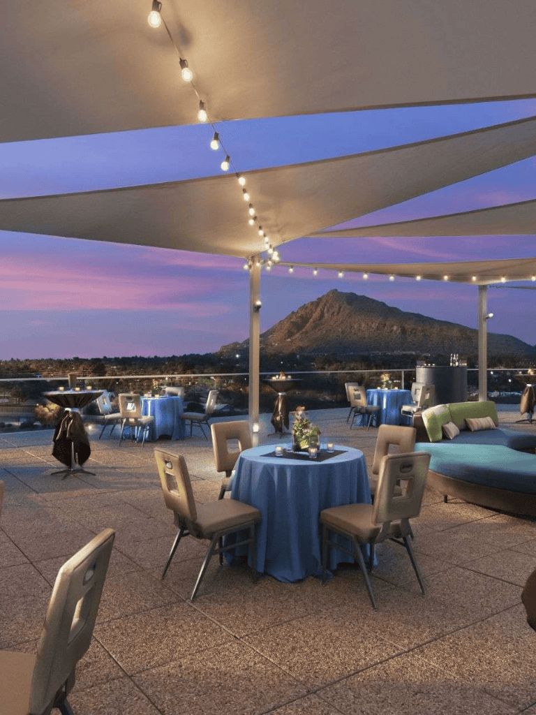 Elegant rooftop dining area with scenic mountain view at sunset, perfect for special occasions and outdoor events.