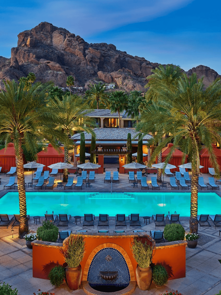 Luxurious resort pool with palm trees and mountain backdrop in Scottsdale, Arizona.