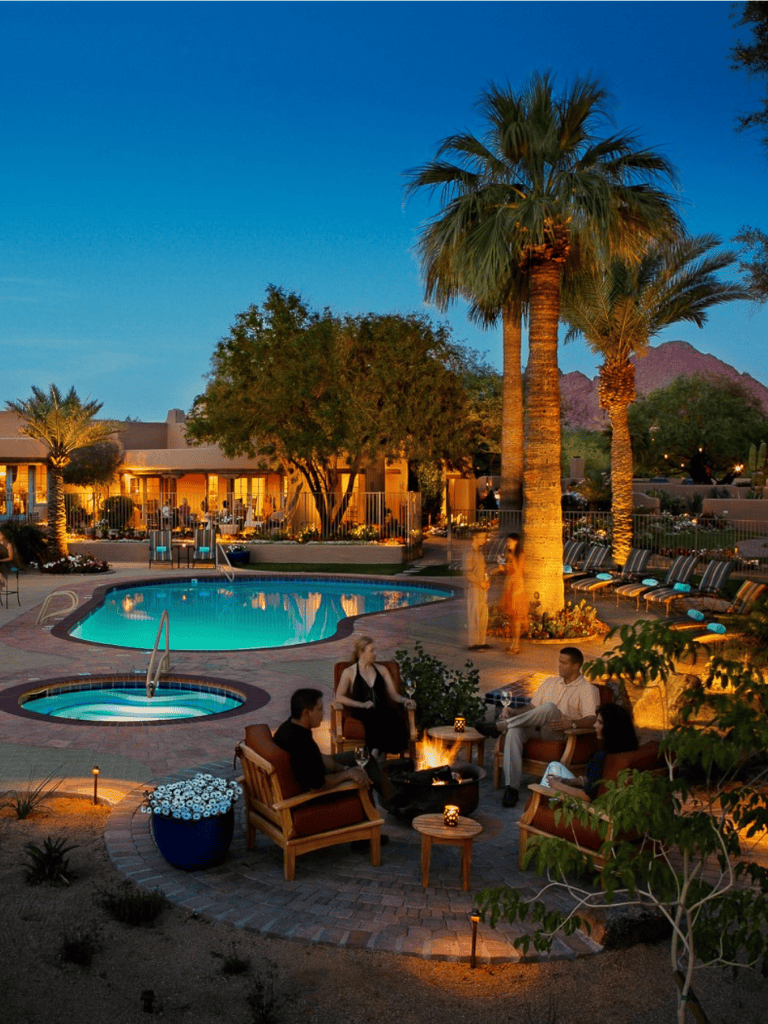 Relaxing poolside evening at a luxurious resort with palm trees and cozy outdoor seating.