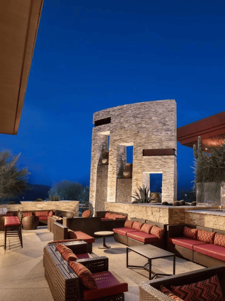 Modern outdoor lounge area at Quest For Directions with stylish seating and contemporary architecture under night sky.