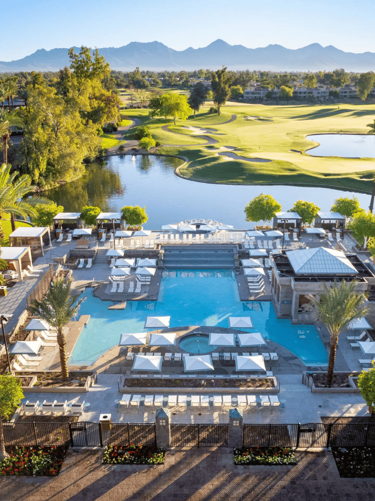 Stunning luxury resort pool with golf course and mountain view in the background.