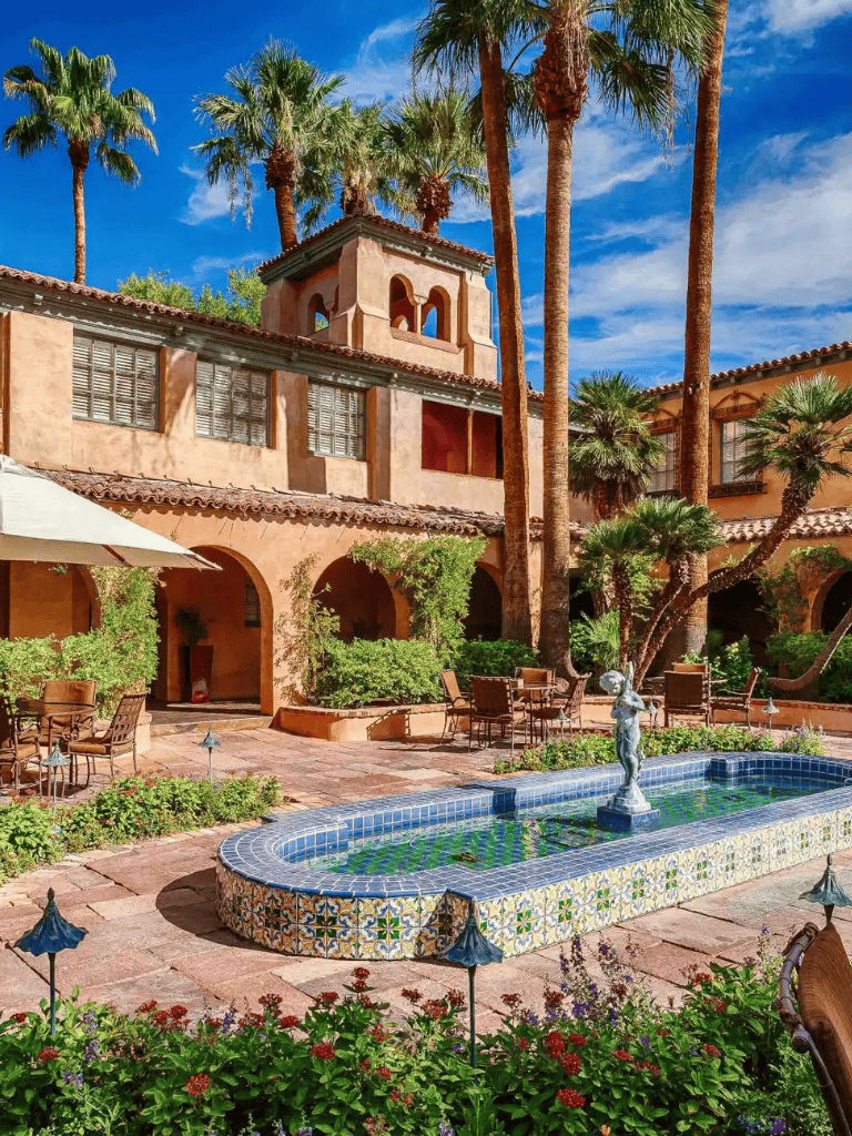 Luxurious Spanish-style courtyard with palm trees and fountain at QuestForDirections property.