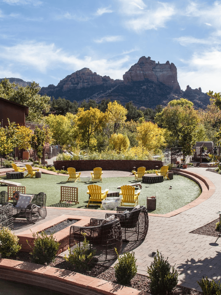 Relaxing outdoor seating area with mountain views, surrounded by colorful trees in nature.