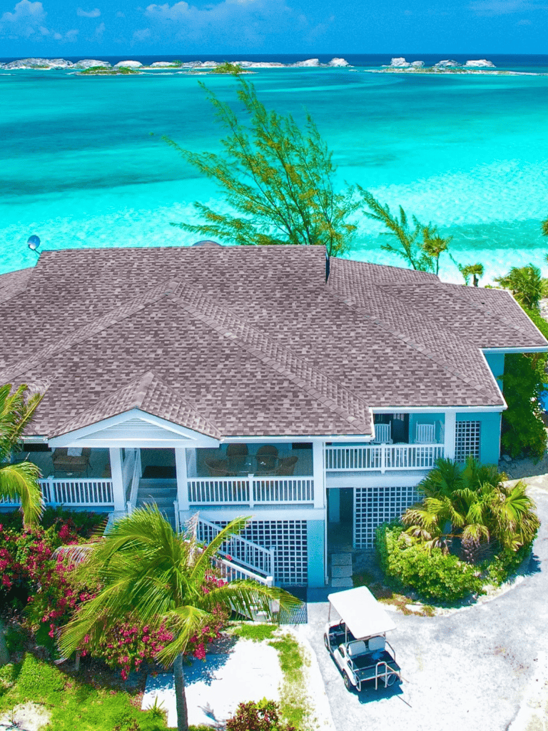 Oceanfront luxury home with tropical landscaping and direct beach access.