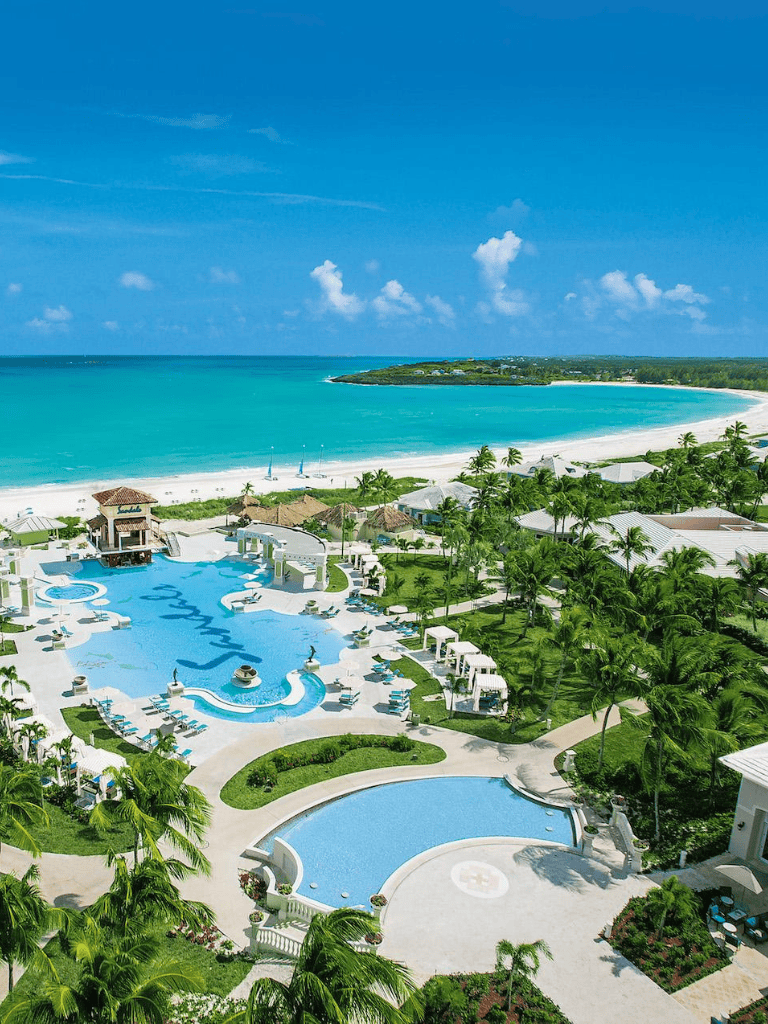 Tropical beach resort with ocean view and luxurious pools, ideal for travel and vacation planning.
