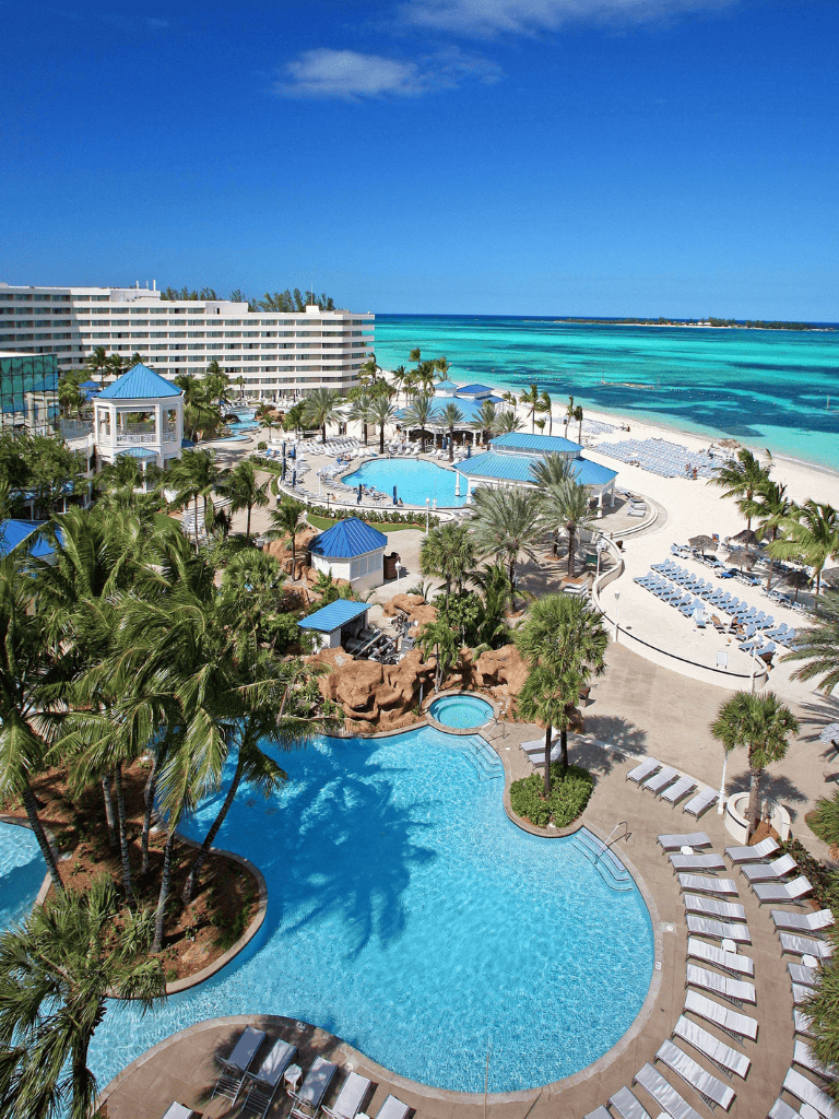 Luxurious beachfront resort with pools, palm trees, and ocean views for a perfect vacation.