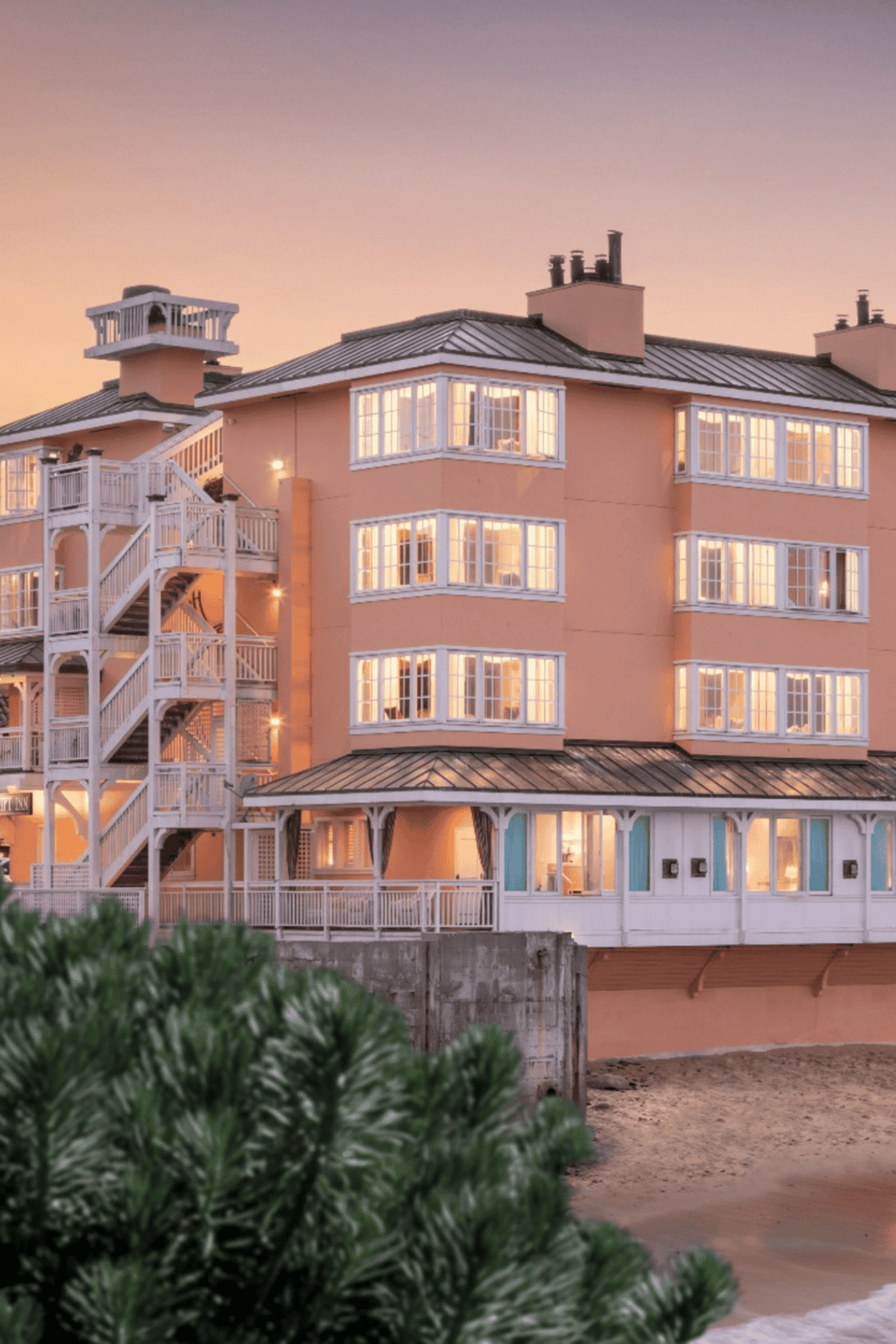 Oceanfront luxury hotel with vibrant sunset view, cozy interior, and seaside charm.