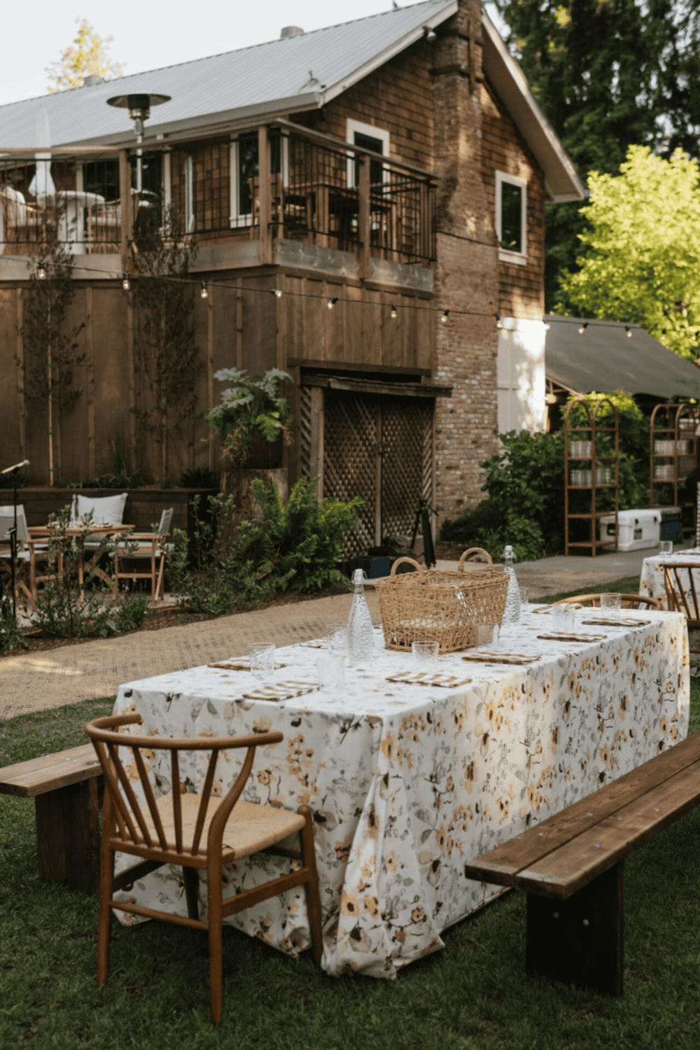 Charming outdoor dining area with farmhouse table, rustic benches, and garden backdrop.