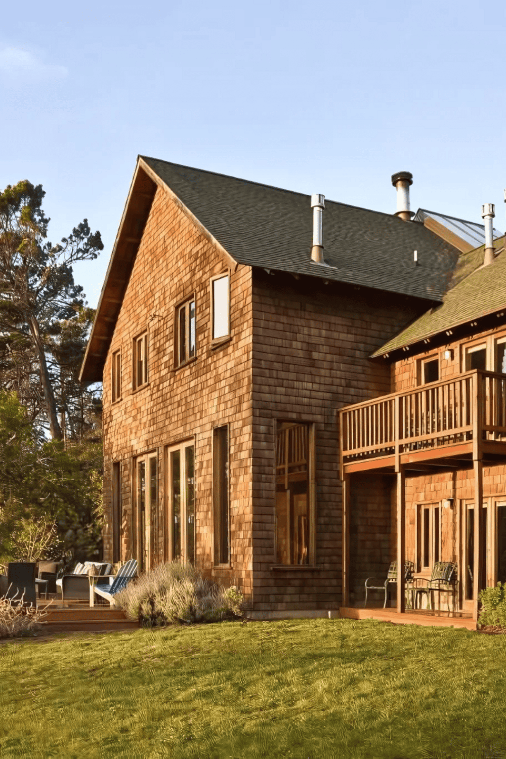 1. Modern wooden house with multiple windows and outdoor deck, surrounded by trees and greenery.