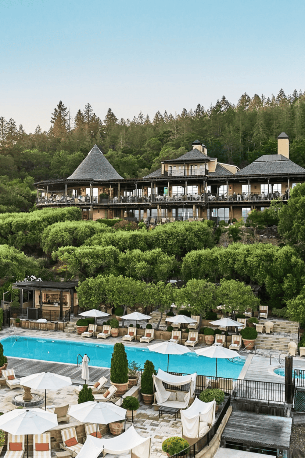 Luxurious mountain resort with swimming pool, outdoor lounge, and scenic hillside views.