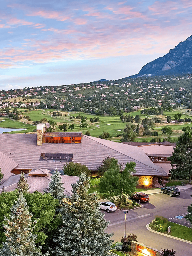 Serene mountain golf course view at sunset, lush greenery, and scenic landscape.