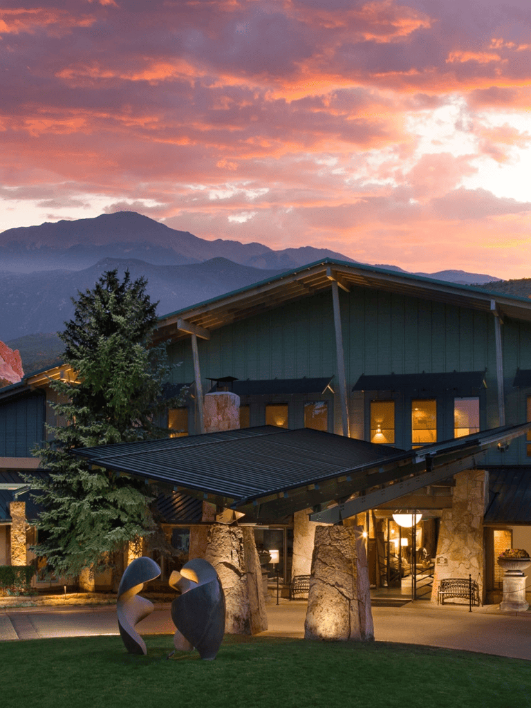 Mountain lodge at sunset with scenic mountain views in the background.