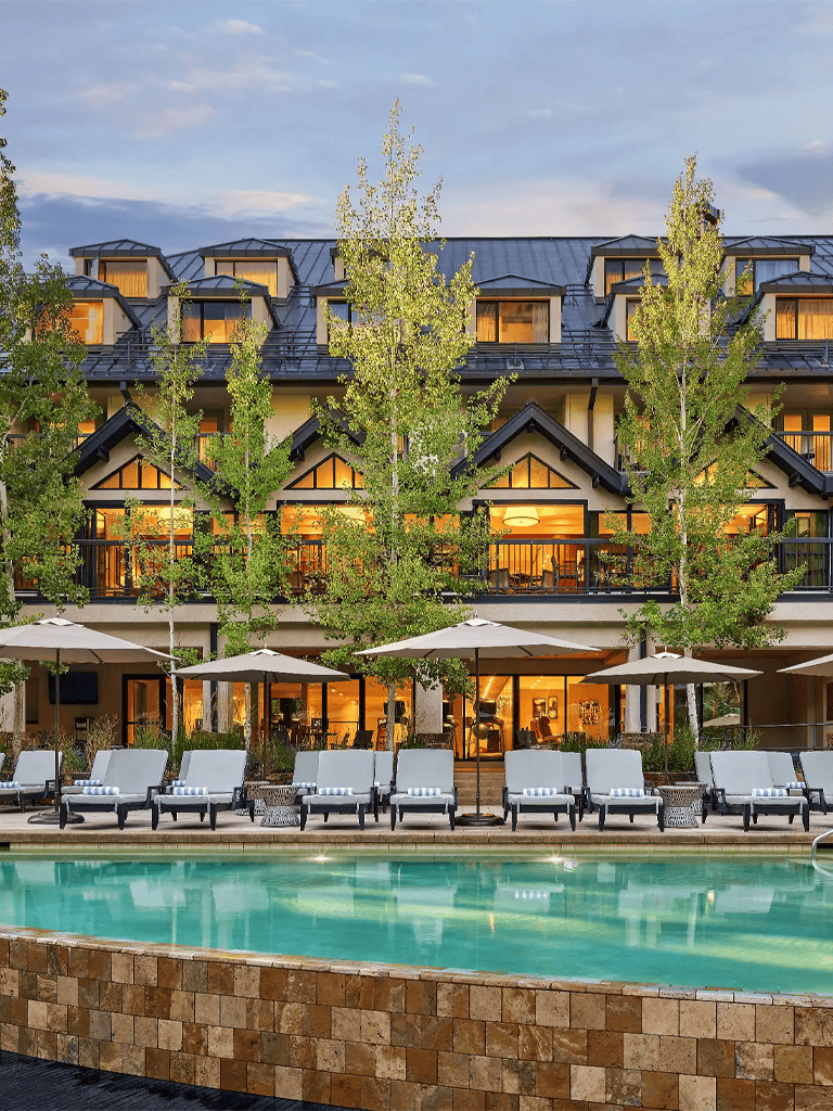 Elegant hotel with outdoor pool and lush greenery, perfect for a relaxing getaway.