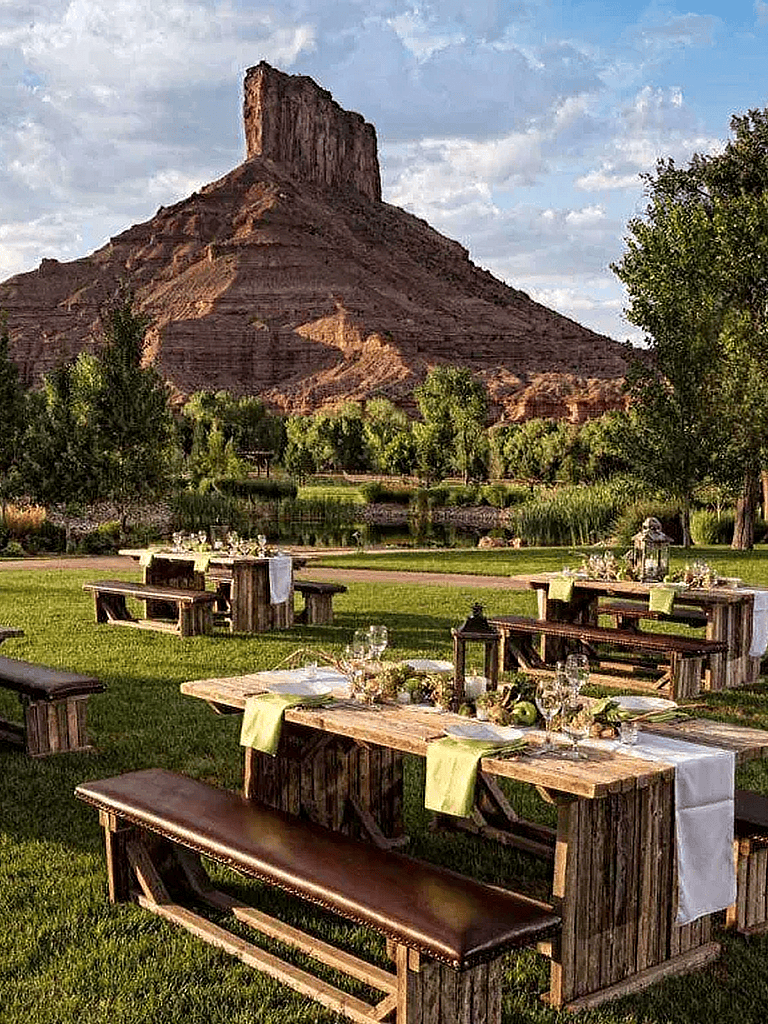 Rustic outdoor dining setup with mountain views and lush greenery. Perfect for scenic gatherings and events.