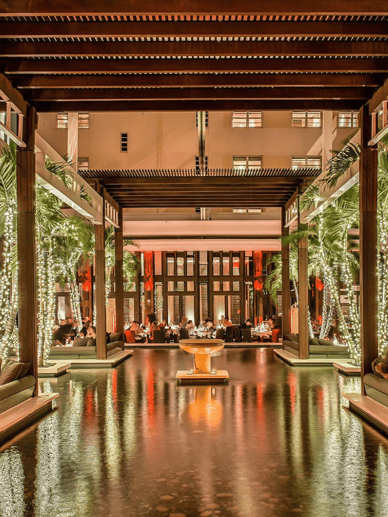 Elegant hotel lobby with lush greenery, ambient lighting, and luxurious furnishings for a serene guest experience.