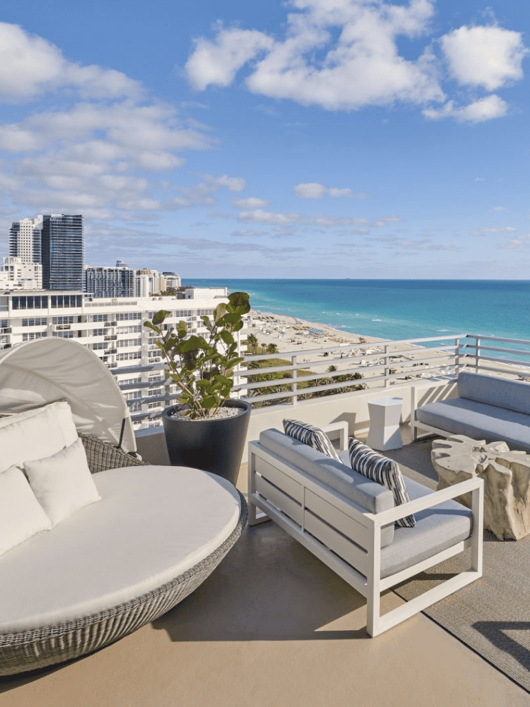 Relaxing beachside balcony with ocean view and modern outdoor furniture, perfect for vacation stay.