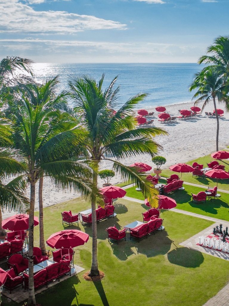 Luxurious beach resort with palm trees, outdoor seating, and ocean view for relaxing vacations.