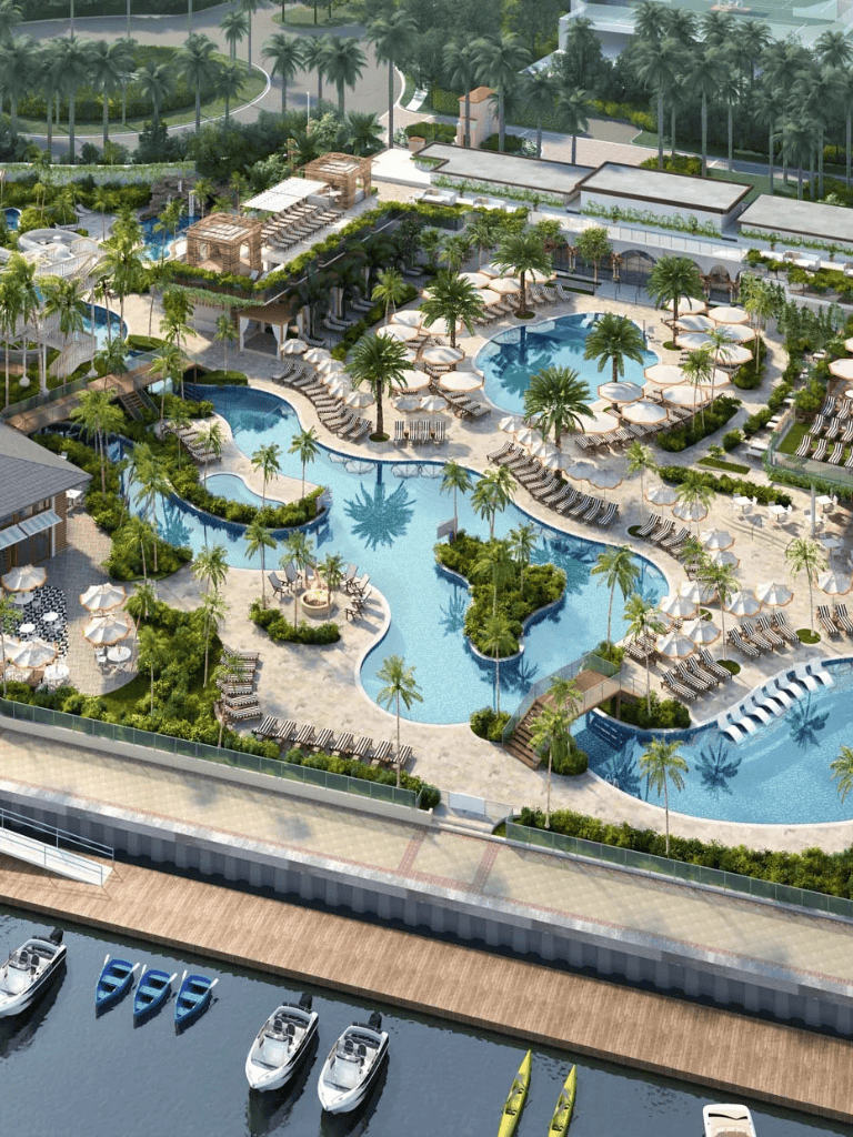 Spacious tropical resort pool area with cabanas, loungers, and lush landscaping.