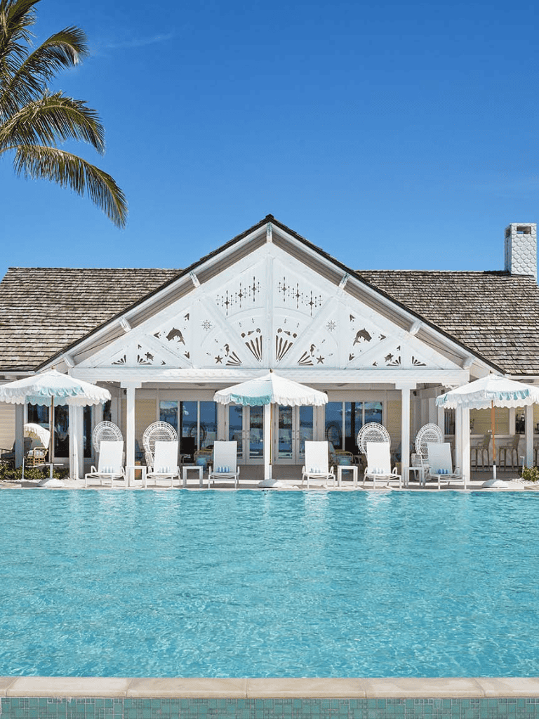 Bright Poolside Resort with White Lounge Chairs and Umbrellas, Tropical Paradise Setting.