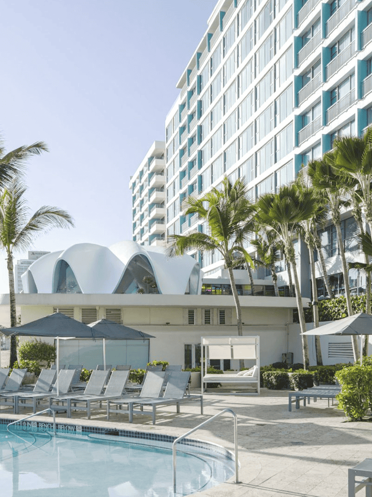Modern beachfront hotel with pool and lounge area in Miami Beach.