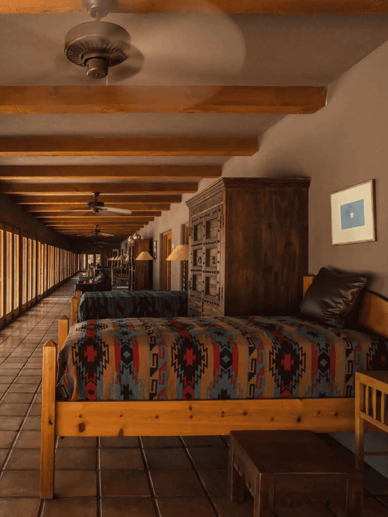 Cozy hotel room with rustic decor, wooden beams, and a balcony view at Quest for Directions.