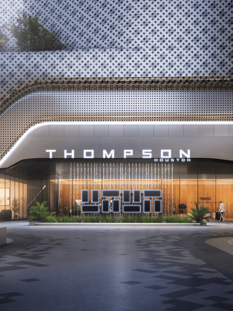 Modern building exterior with illuminated "THOMPSON" sign in Houston, innovative architecture, and landscaping.