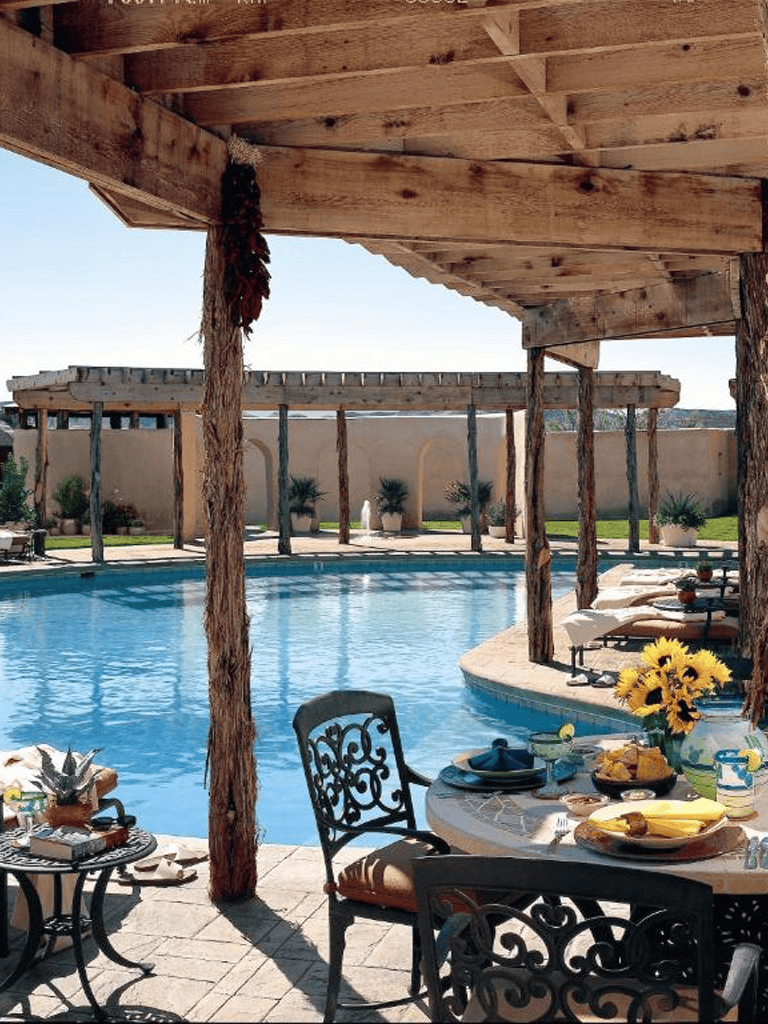 Relaxing outdoor poolside setting with dining area and sunflowers, perfect for vacation or leisure.