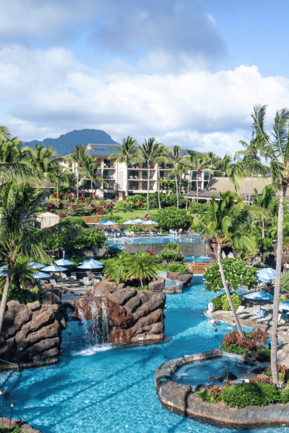 Luxurious tropical resort with swimming pools and lush landscaping in a scenic mountain setting.