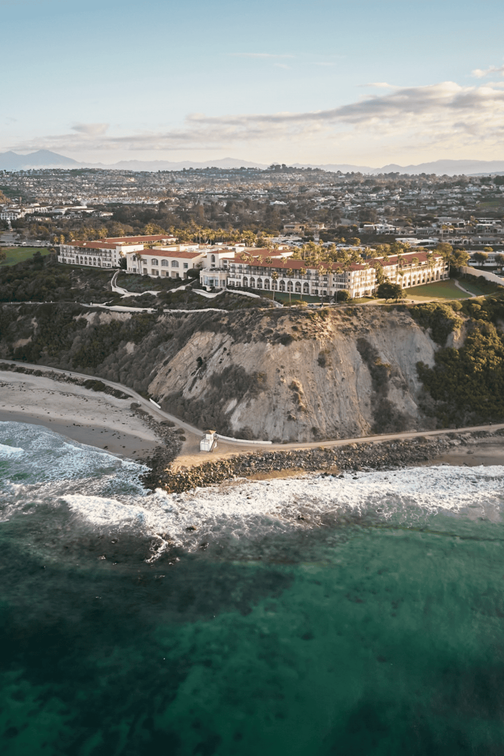 Luxury coastal resort on cliffs overlooking the ocean with scenic city views.