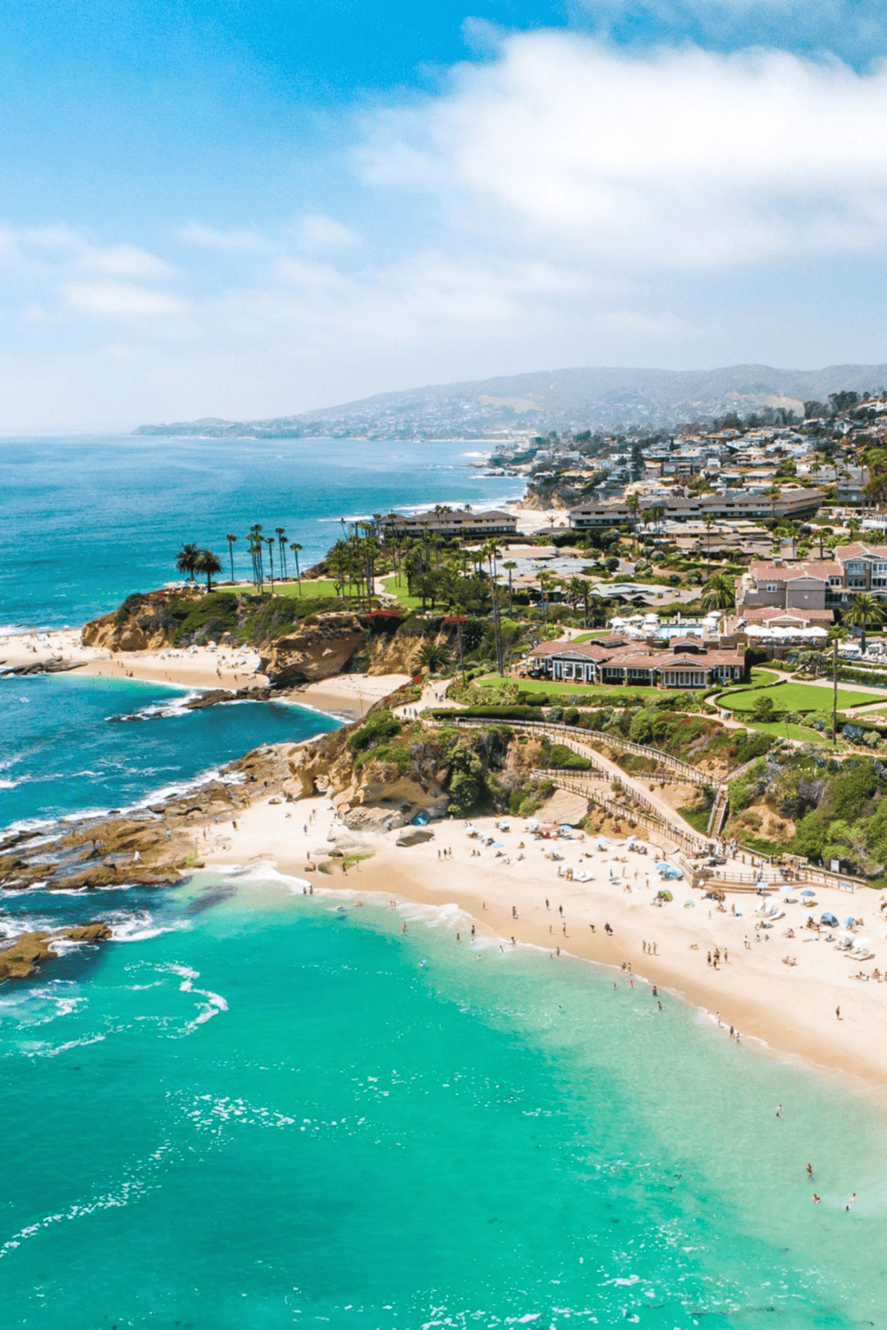 Vibrant aerial view of coastal cliffs and sandy beaches in California, highlighting scenic oceanfront and luxurious homes.