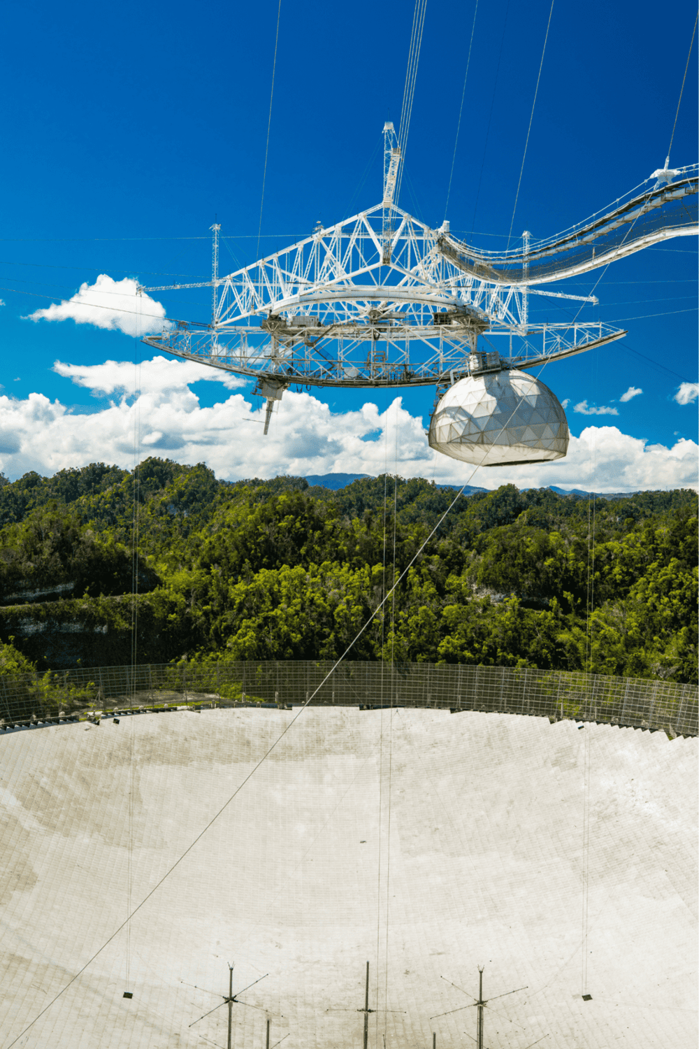 High-altitude radio telescope dish in natural surroundings for scientific research and astronomical observation.