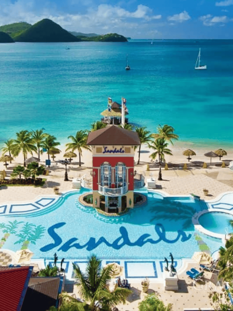 Luxury beachfront resort in Sandals with pool, lush palm trees, ocean views, and vibrant tropical scenery.