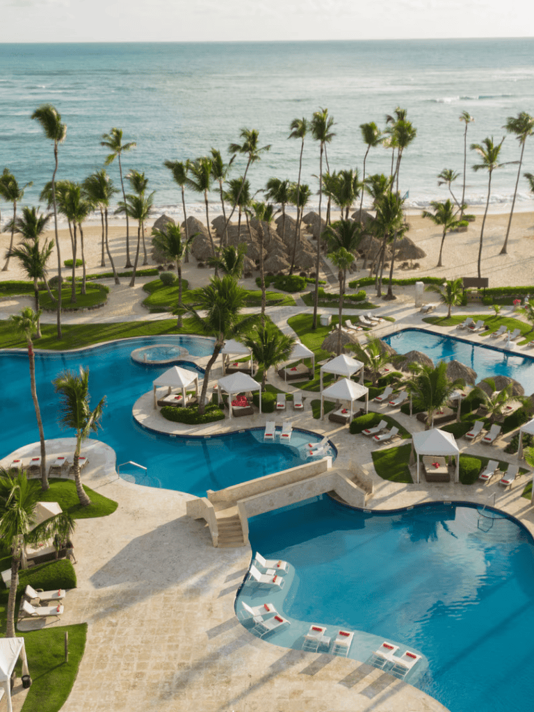 Luxurious beach resort pool with ocean view and palm trees for a relaxing vacation.