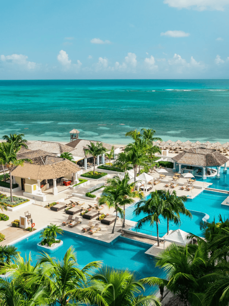 Luxurious beach resort with infinity pools, palm trees, and ocean views in tropical seaside destination.