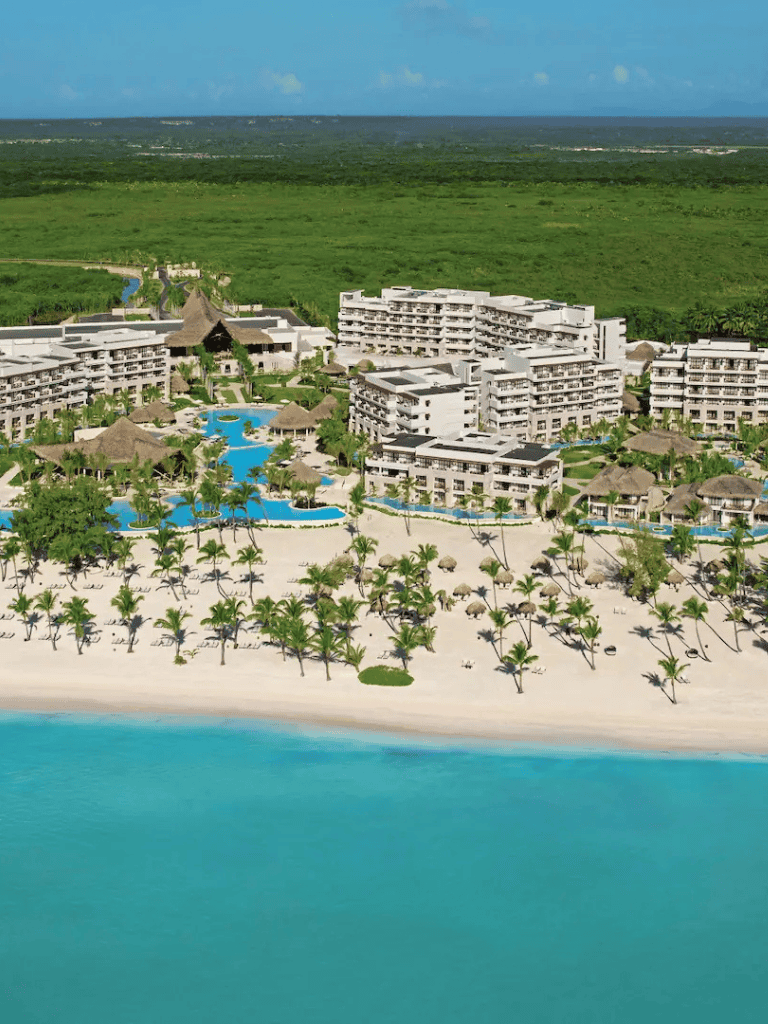 Luxurious beachfront resort with pools and palm trees, set in a tropical paradise.