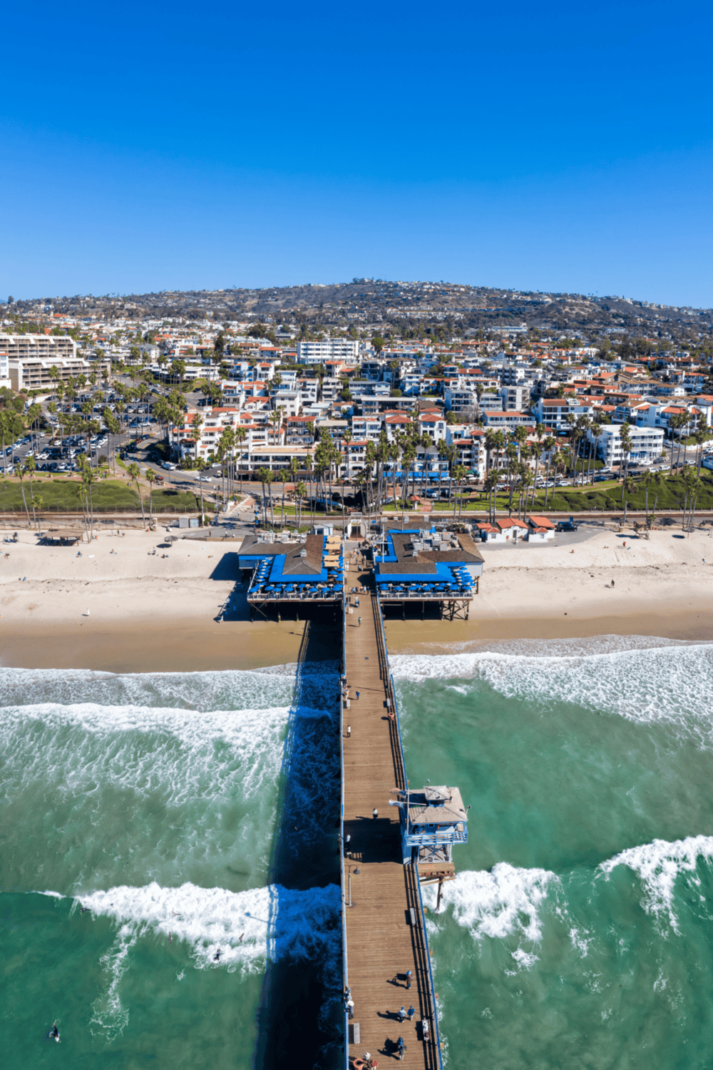 Vibrant coastal town with a pier, beach, and ocean views in sunny California.