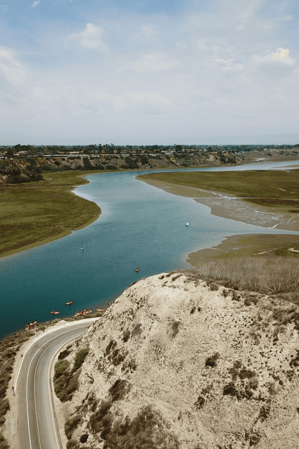 Serene river landscape with winding waterway, hills, and boaters, perfect for nature and navigation enthusiasts.