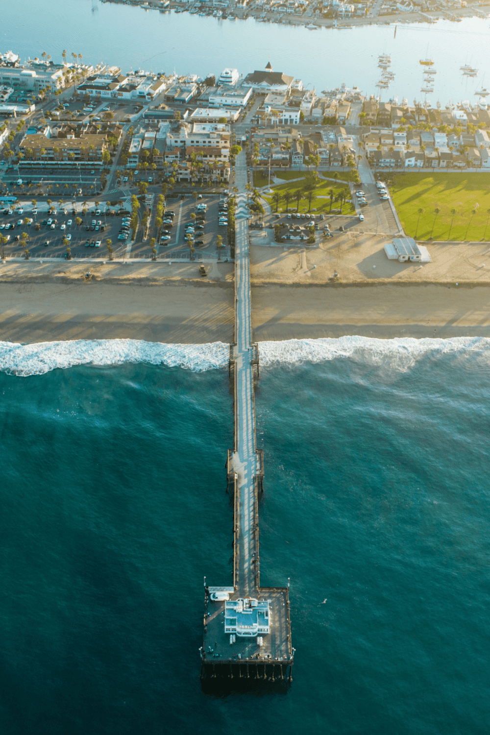 Beach pier with ocean view and coastal townscape, perfect for seaside tourism and maritime activities.
