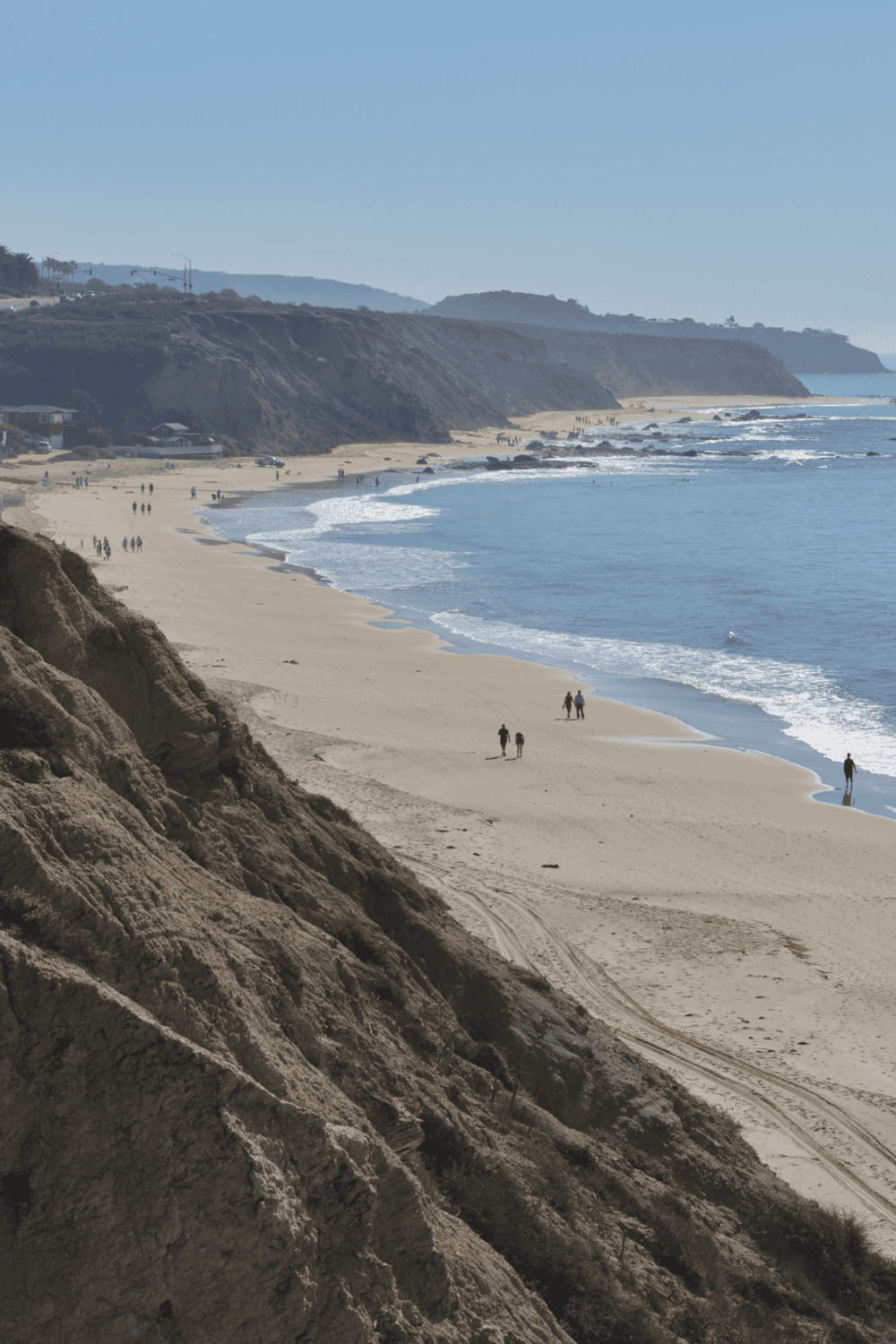 Coastal beach with cliffs and ocean waves, ideal for scenic ocean view travel and coastal exploration.