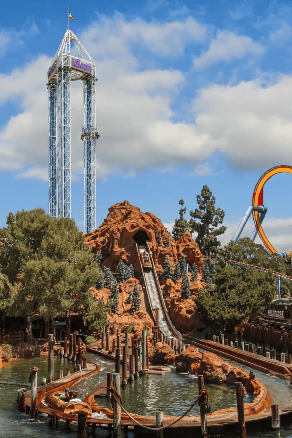 Thrilling roller coaster at Quest for Directions amusement park with scenic mountain and water features.