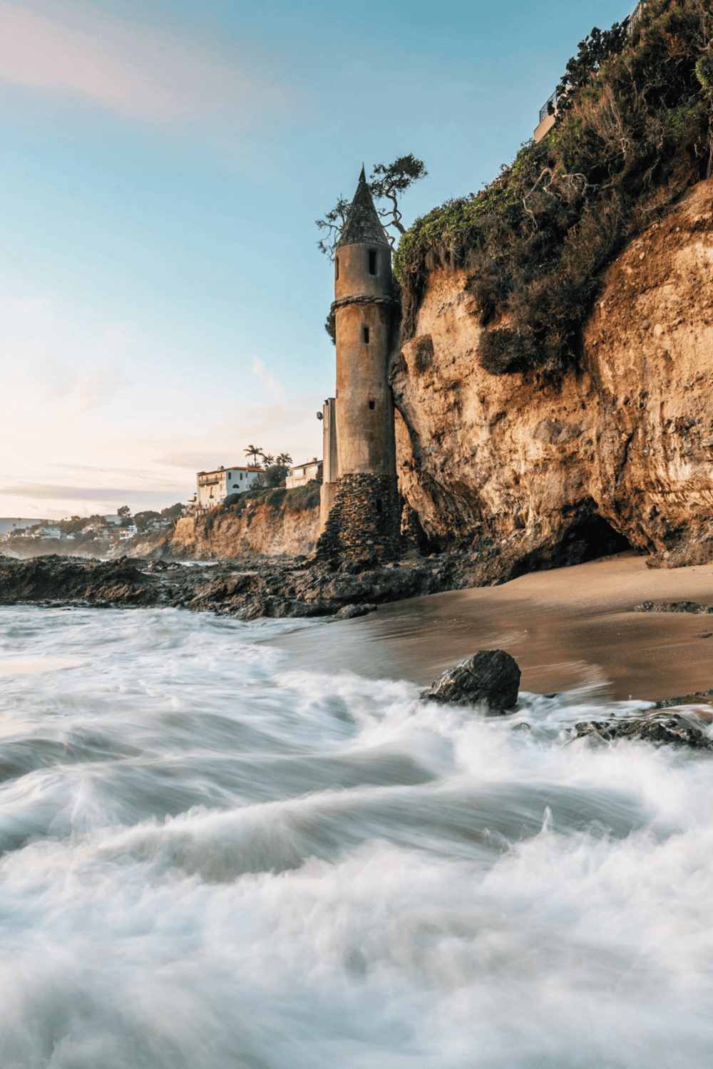 Seaside castle with dramatic cliffs and ocean waves, scenic coastal view for travel and adventure seekers.