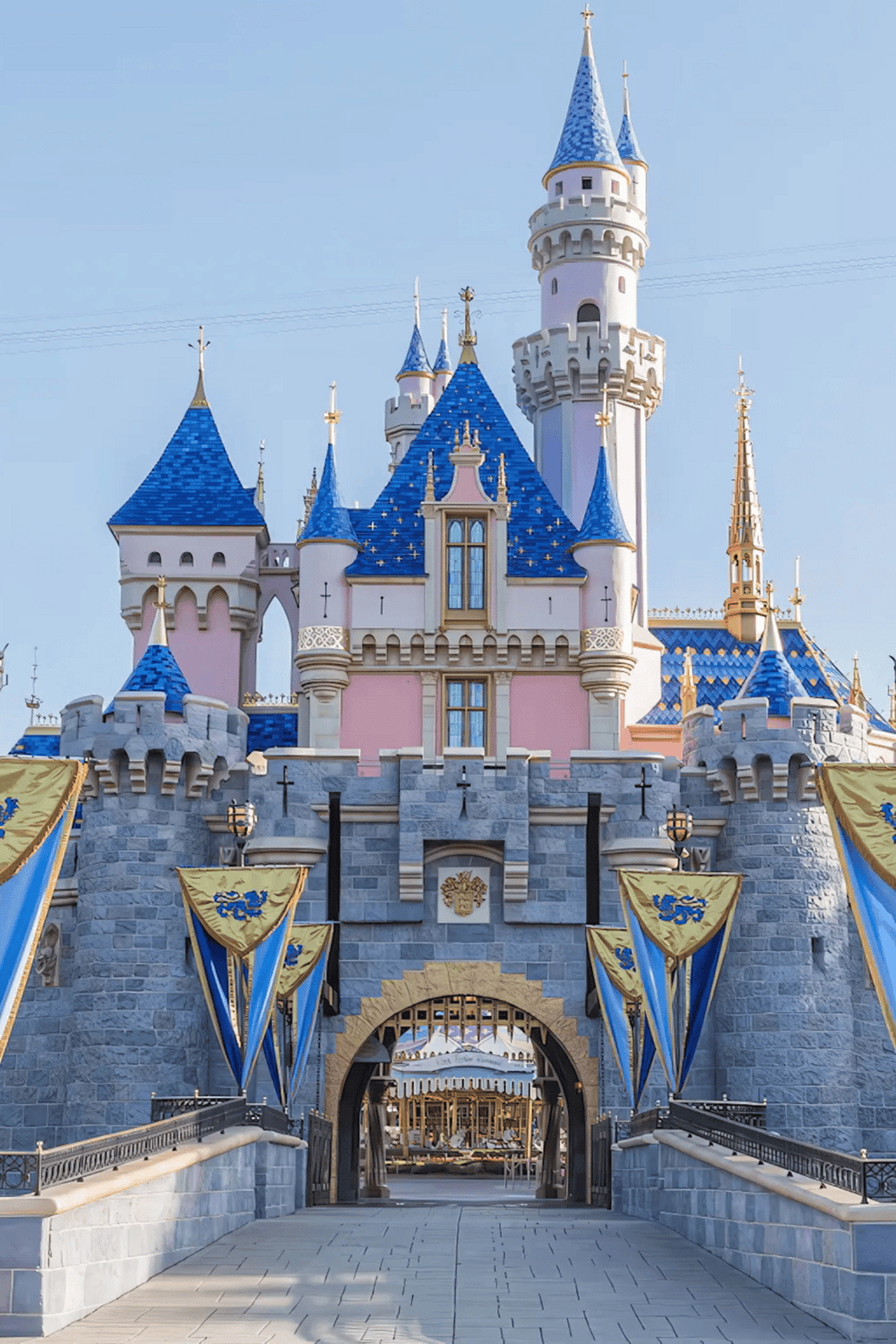 Magical Disney castle with blue turrets and pink walls, iconic fairy tale destination for visitors.