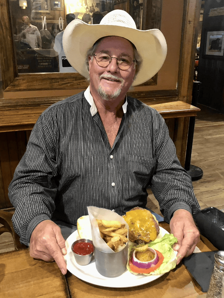 Enjoying a classic American burger with fries at a cozy restaurant.