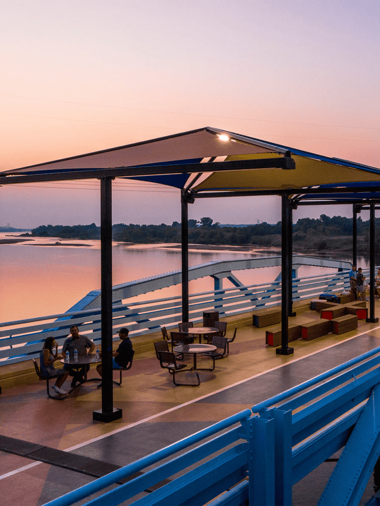 Relaxing riverside dining at QuestForDirections outdoor deck during sunset in a scenic setting.