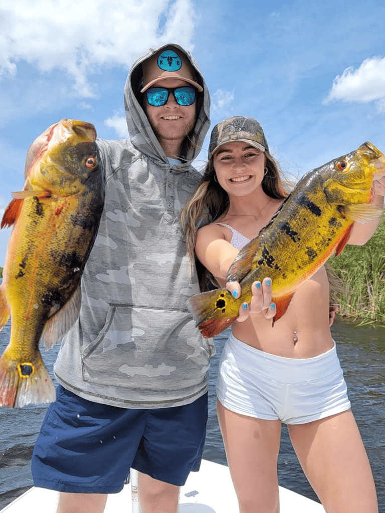 Large caught fish by happy anglers fishing freshwater river in summer outdoors.